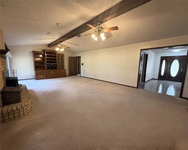 en empty room with windows and chandelier