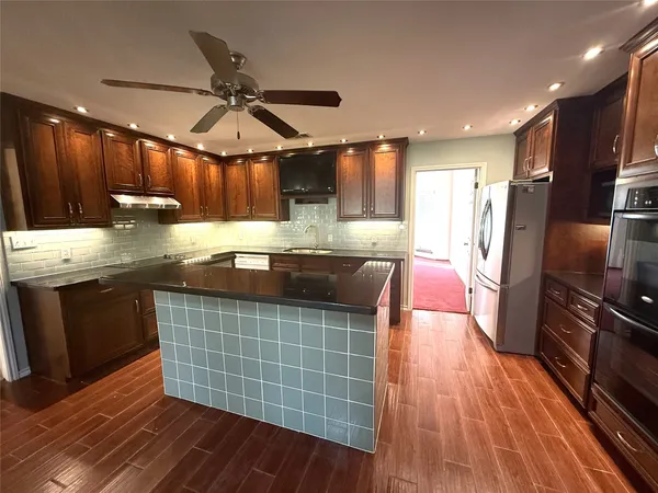 a kitchen with a sink a counter space stainless steel appliances and cabinets