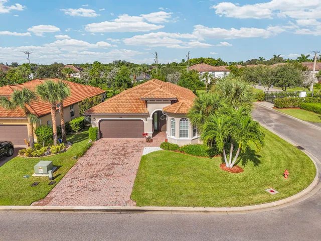 a view of a big house with a big yard and large trees