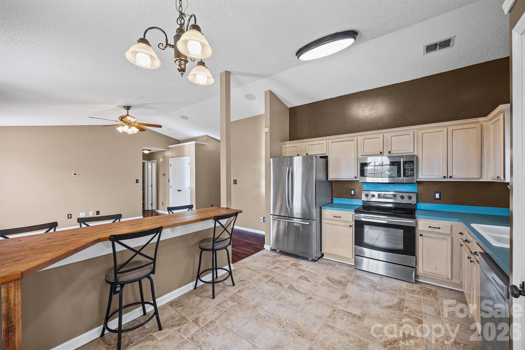 132 Sella Ridge Drive Mount Holly, NC 28120 - Photo 11 of 28 a kitchen with stainless steel appliances kitchen island granite countertop a table chairs in it and wooden floors