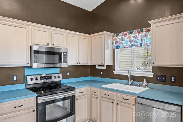 a kitchen with stainless steel appliances a stove sink and microwave