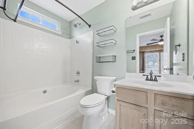 a bathroom with a sink toilet vanity and shower