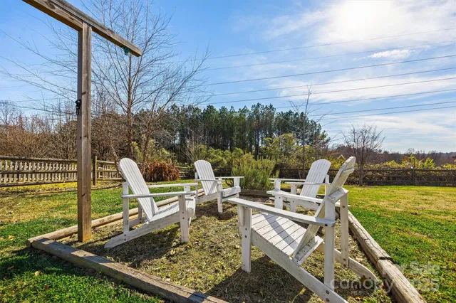 a view of a chair and tables in the patio next to a yard