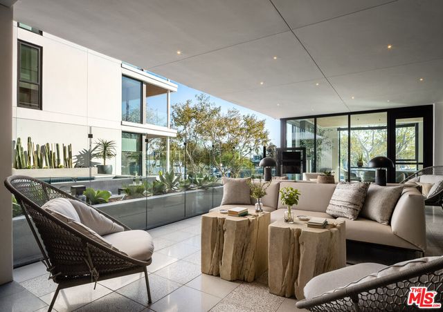 a living room with furniture kitchen view and a large window