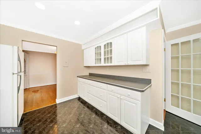 a kitchen with white cabinets and a wooden floor