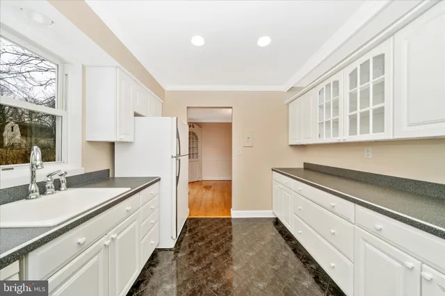 a kitchen with granite countertop a sink stove and cabinets