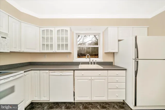 a kitchen with granite countertop a sink and a refrigerator