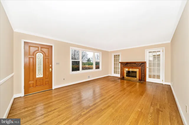 a view of empty room with wooden floor and fireplace