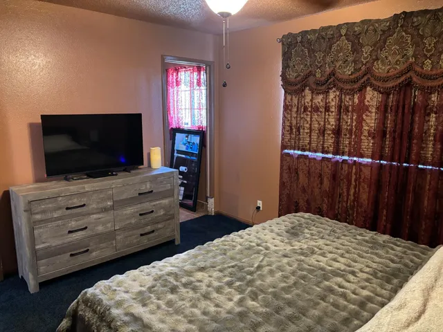 a view of a room with wooden floor and a ceiling fan