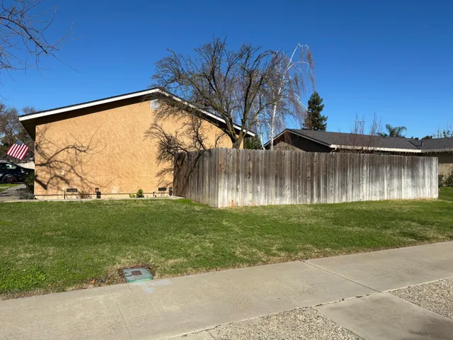 a backyard of a house with lots of green space and fountain