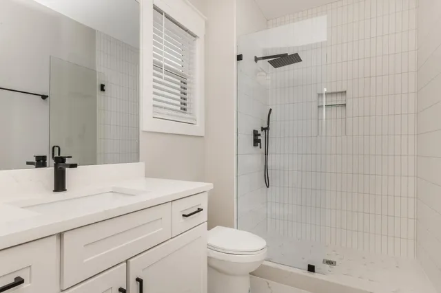 a bathroom with a sink a toilet and shower