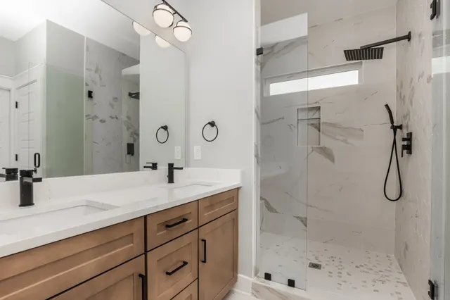 a bathroom with a granite countertop sink a shower and mirror