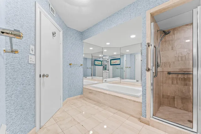 a bedroom with a bed large window and couch