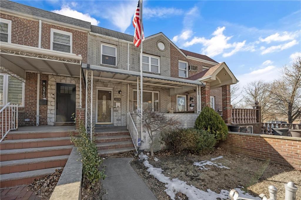 63-08 77th Street Queens, NY 11379 - Photo 1 of 1 View of property featuring a porch and brick siding