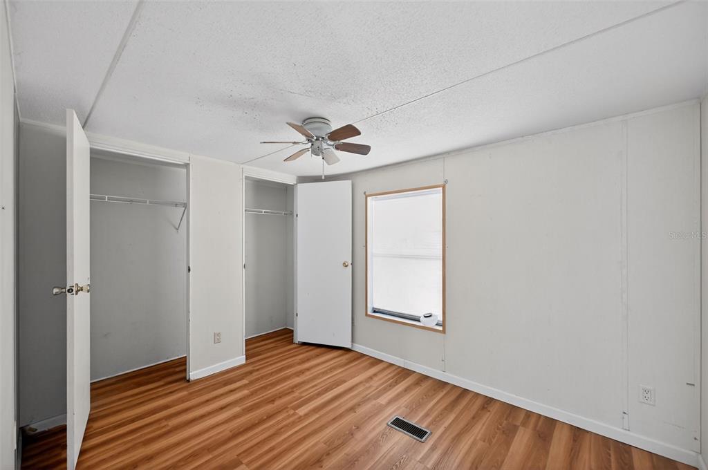 7405 Bonnie Lake Road Brooksville, FL 34601 - Photo 11 of 14 a view of an empty room with wooden floor and a window