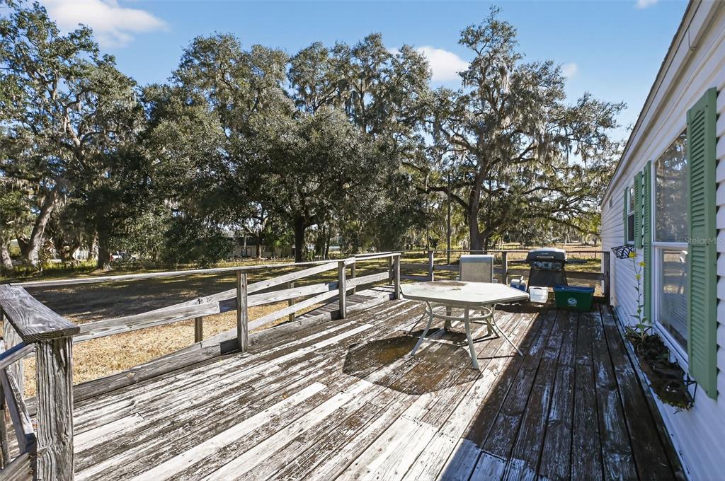 7405 Bonnie Lake Road Brooksville, FL 34601 - Photo 2 of 14 a view of balcony with wooden floor and iron fence