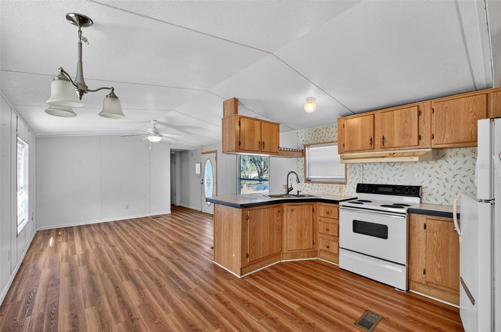 7405 Bonnie Lake Road Brooksville, FL 34601 - Photo 5 of 14 a kitchen with granite countertop wooden floors and stainless steel appliances