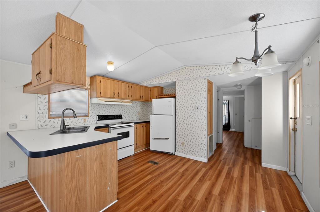 7405 Bonnie Lake Road Brooksville, FL 34601 - Photo 6 of 14 a kitchen with stainless steel appliances granite countertop a sink dishwasher and a stove with wooden floor