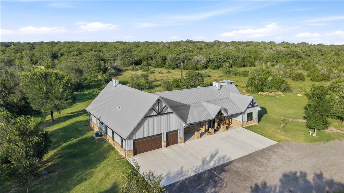175 Wilson Road Elgin, TX 78621 - Photo 4 of 40 The main home sits on a huge, beautifully cleared lot surrounded by dense woods, giving you total peace and quiet. You can see how the modern farmhouse architecture blends perfectly into the countryside.