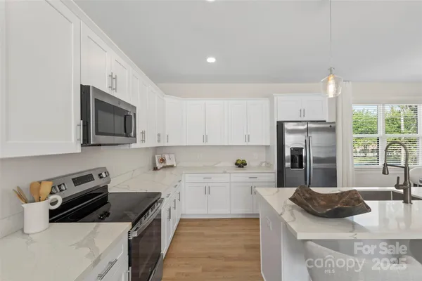 a kitchen with stainless steel appliances granite countertop a sink stove and refrigerator