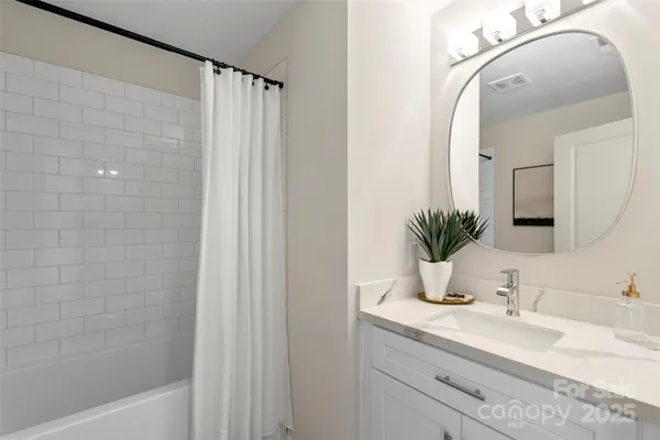 a bathroom with a granite countertop sink a mirror and shower