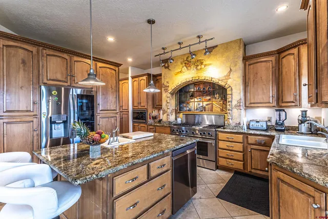 a kitchen with stainless steel appliances granite countertop a stove and cabinets