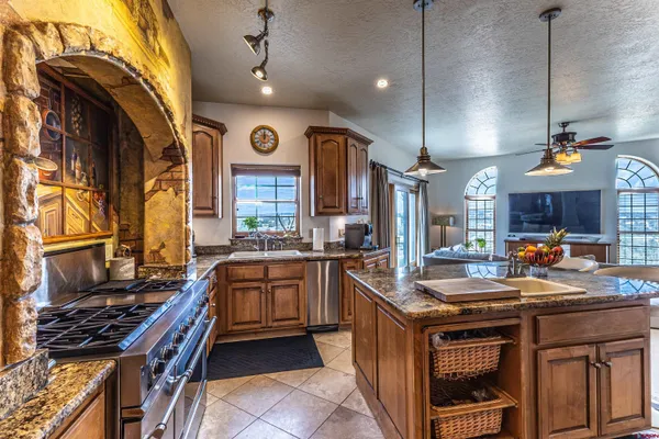 a kitchen with stainless steel appliances granite countertop a stove a sink dishwasher and a microwave