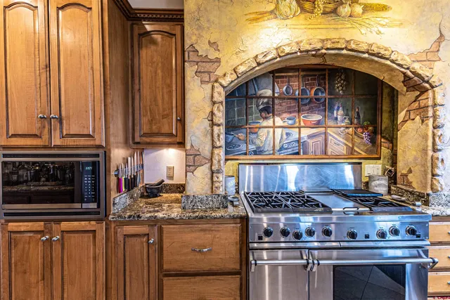a kitchen with stainless steel appliances granite countertop a stove and a microwave