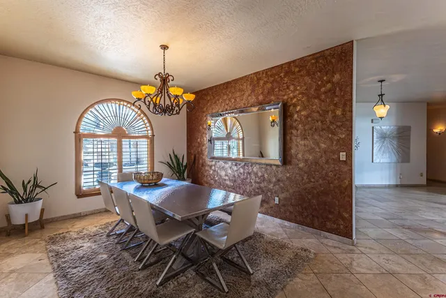 a dining room with furniture a chandelier and wooden floor