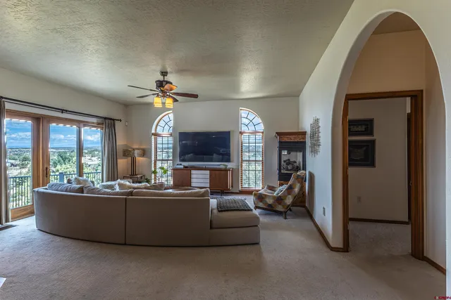 a living room with furniture a chandelier and a large window