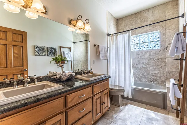 a bathroom with a double vanity sink mirror and a bathtub