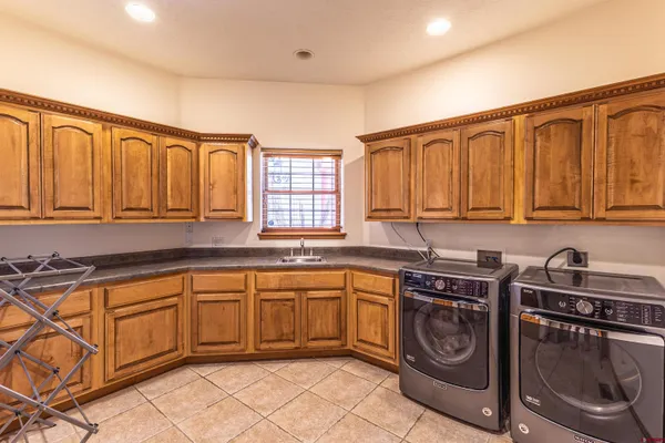 a kitchen with stainless steel appliances granite countertop a sink a stove a washer and dryer