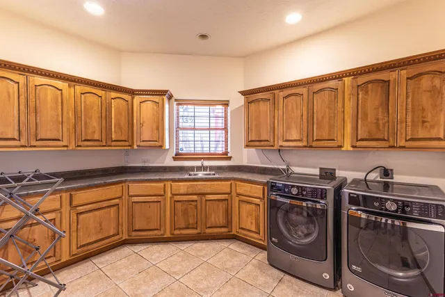 a kitchen with stainless steel appliances granite countertop a sink a stove a washer and dryer