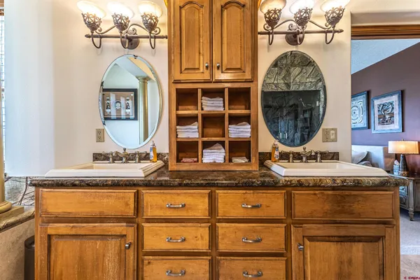 a bathroom with a granite countertop double vanity sink and a mirror
