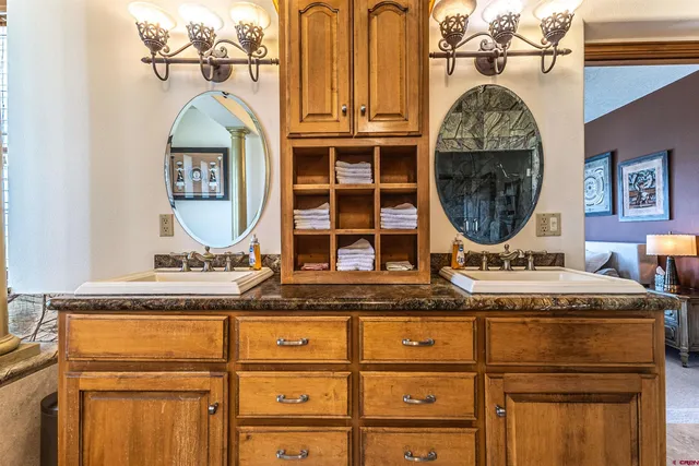 a bathroom with a granite countertop double vanity sink and a mirror