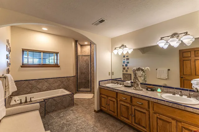 a spacious bathroom with a bathtub double sink and mirror