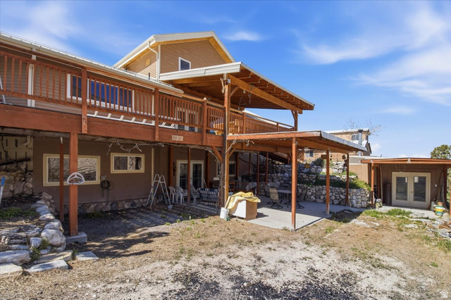 811 East Canyon Road Mayfield, UT 84643 - Photo 7 of 57 Multi-level residence featuring an expansive upper deck with wood railing, a covered lower patio, and a separate detached outbuilding with double doors