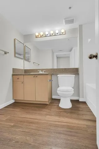 a bathroom with a sink a toilet and a mirror