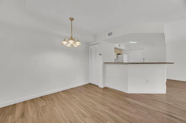 a view of a room with wooden floor and chandelier