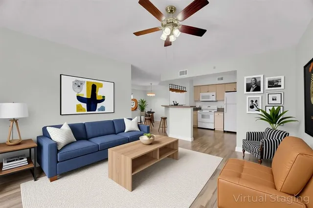 a living room with furniture and a view of kitchen