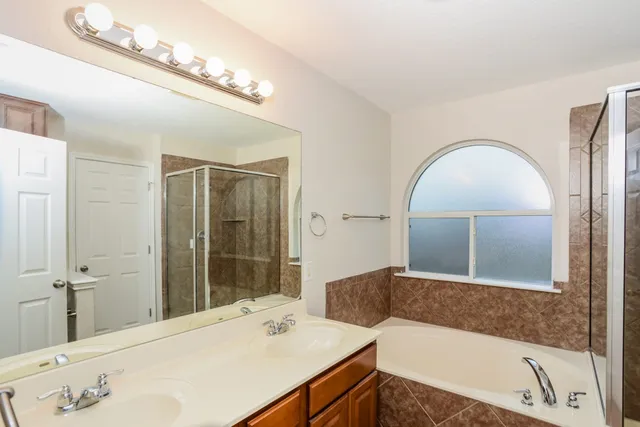 a en suite bathroom with a tub and a large mirror