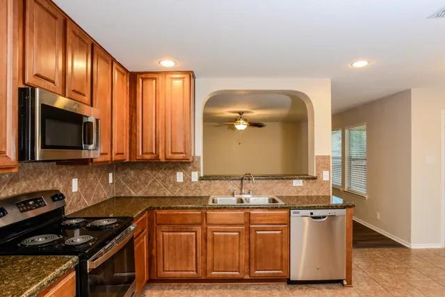 a kitchen with granite countertop a stove and a sink