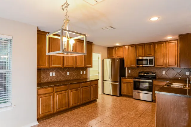 a kitchen with granite countertop stainless steel appliances and wooden cabinets