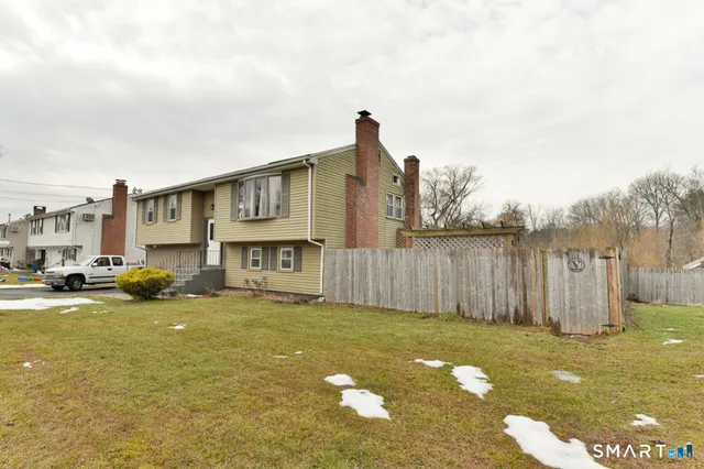 a view of a house with a yard and sitting area