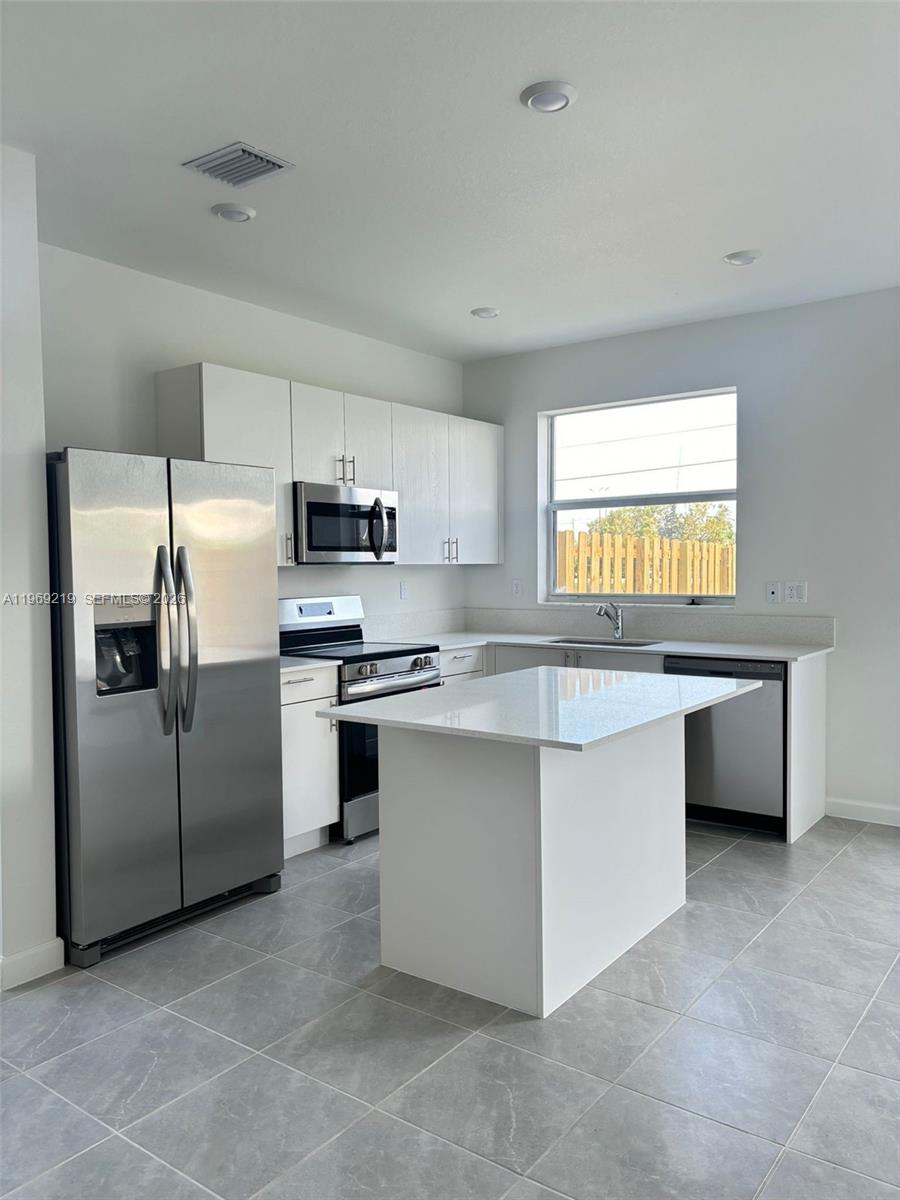 29228 Southwest 163rd Court Homestead, FL 33033 - Photo 4 of 18 a kitchen with stainless steel appliances a refrigerator sink and stove