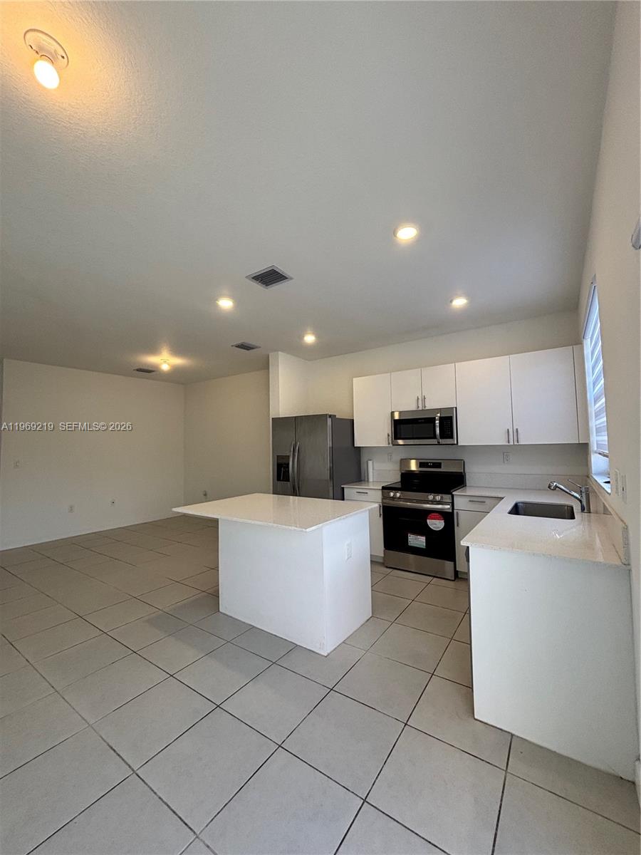 29228 Southwest 163rd Court Homestead, FL 33033 - Photo 5 of 18 a kitchen with a sink and white cabinets