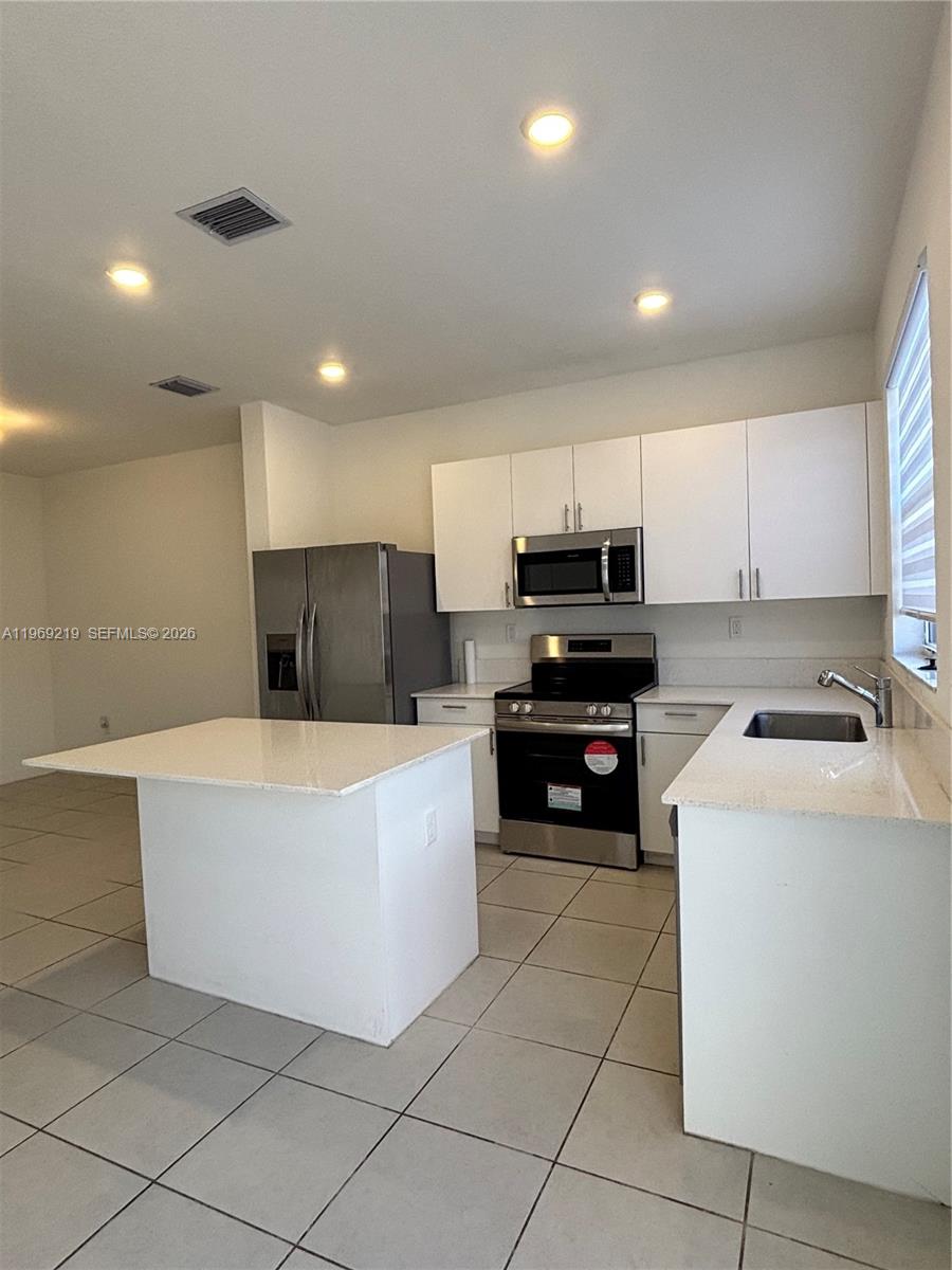 29228 Southwest 163rd Court Homestead, FL 33033 - Photo 6 of 18 a kitchen with a sink a stove top oven and cabinets