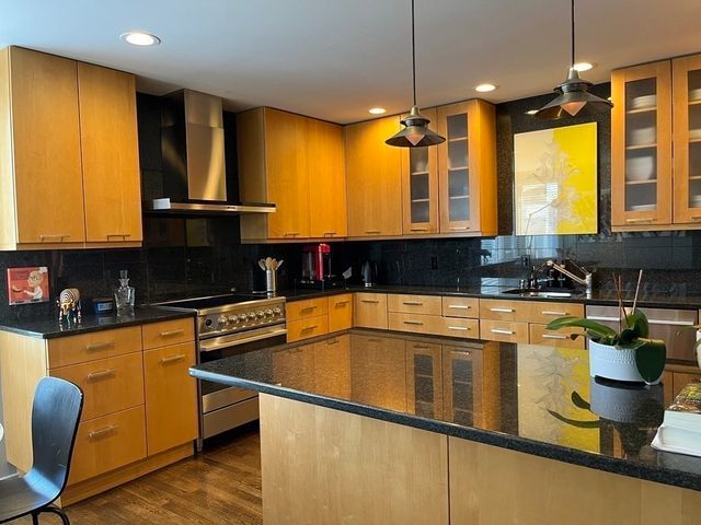 a bathroom with a granite countertop toilet sink shower and mirror