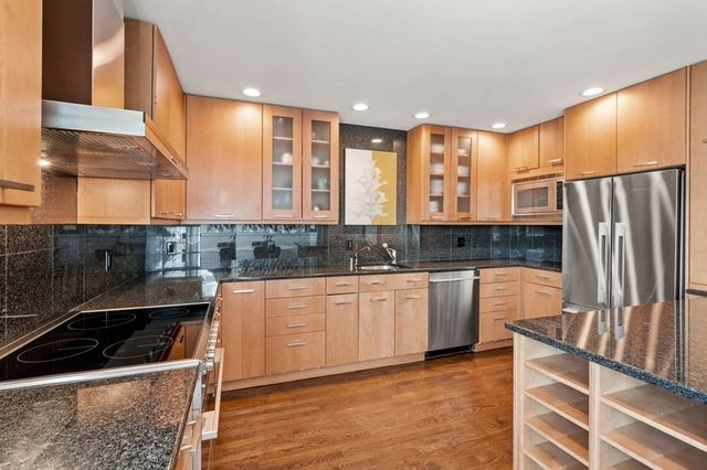 a bedroom with furniture and three large window