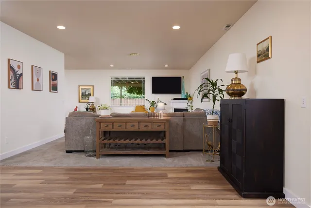 a view of a hallway with wooden floor and furniture